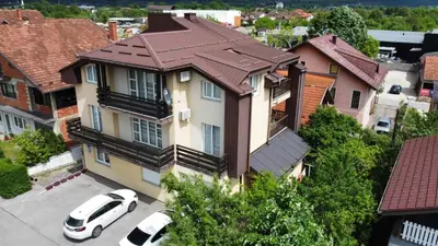 a white car parked in front of a house at Apartman Jasmina in Bihać