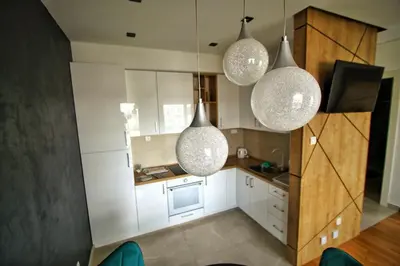 a kitchen with three lights hanging from the ceiling at Downtown apartment in Banja Luka