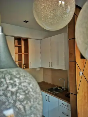 a kitchen with white cabinets and a sink at Downtown apartment in Banja Luka