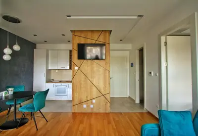 a kitchen and a living room with a table and chairs at Downtown apartment in Banja Luka