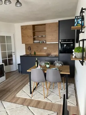 a kitchen with a wooden table and chairs in a room at Planinski raj in Kupres