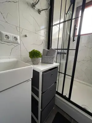 a white bathroom with a sink and a shower at Planinski raj in Kupres