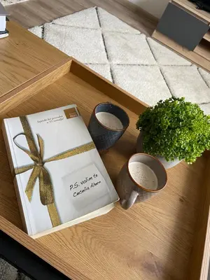 a wooden table with a book and a plant at Planinski raj in Kupres