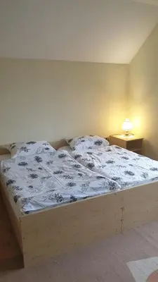a bed with a white comforter in a bedroom at Apartman Darko in Kupres