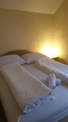 a bedroom with two beds with white sheets and pillows at Apartman Darko in Kupres