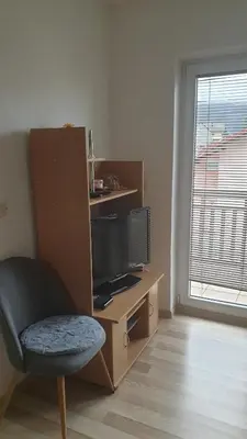 a room with a tv and a chair and a window at Apartman Darko in Kupres