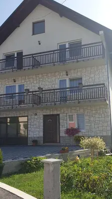 a large white brick building with a balcony at Apartman Darko in Kupres