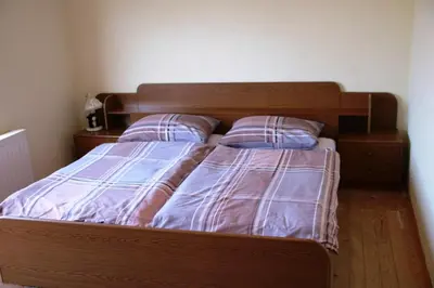 a bedroom with a wooden bed with two pillows at Apartman Darko in Kupres