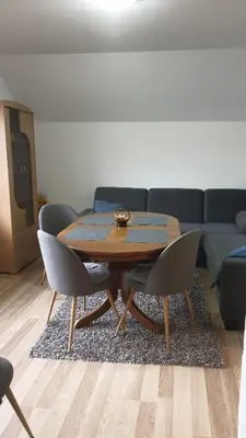 a table and chairs in a living room with a couch at Apartman Darko in Kupres