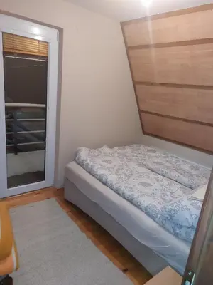 a small bedroom with a bed and a window at Vikendica Grganović in Vlasic