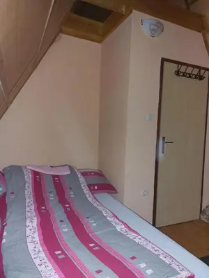 a bedroom with a bed with a red and gray blanket at Vikendica Grganović in Vlasic