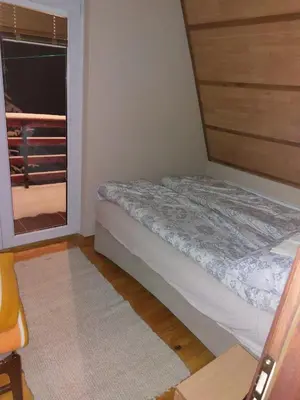 a small bedroom with a bed and a window at Vikendica Grganović in Vlasic