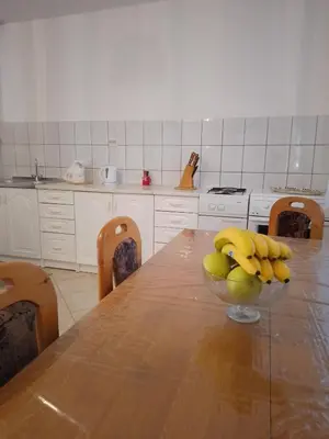 a kitchen with a table with a bowl of bananas on it at Barun apartman in Lusnić