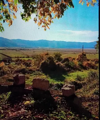 a view of a field with mountains in the distance at Barun apartman in Lusnić