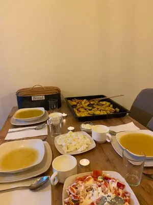 a table with plates of food and a tray of food at Apartman Green in Šišava