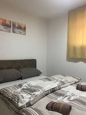 a bed with a zebra blanket on it in a bedroom at Apartman Green in Šišava