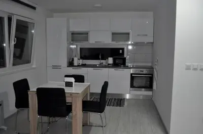 a kitchen with white cabinets and a table and chairs at Perfect Holidays in Vlasic