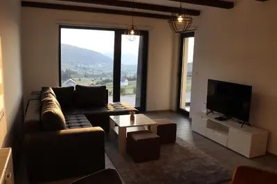 a living room with a couch and a flat screen tv at LUX Apartmani Vlašićka čarolija in Travnik