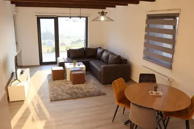 a living room with a couch and a table at LUX Apartmani Vlašićka čarolija in Travnik