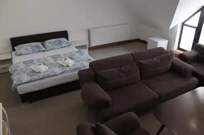 a bedroom with a bed and a couch at Apartmani Vlašić-Petrol in Travnik