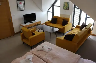a living room with yellow furniture and a tv at Apartmani Vlašić-Petrol in Travnik