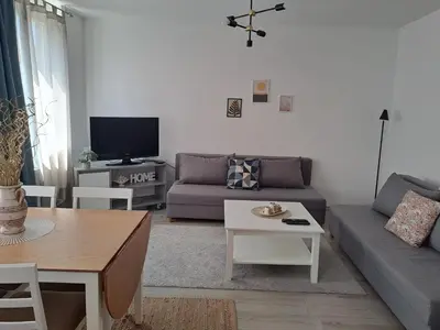 a living room with a couch and a tv at Enjoy traveling in Tuzla