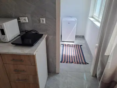 a small kitchen with a refrigerator and a microwave at Enjoy traveling in Tuzla