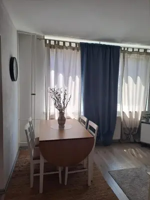 a dining room table with chairs and a vase with flowers at Enjoy traveling in Tuzla