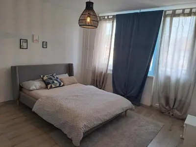 a bed in a bedroom with blue curtains and a lamp at Enjoy traveling in Tuzla