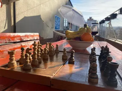 a chess board on a table with a bowl of fruit at Penthouse stan 80m2, terasa 36m2, garaža... centar Banja Luke - gradski park in Banja Luka