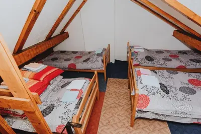 a room with three bunk beds in a attic at Apartments Kiki Vlašić in Vlasic