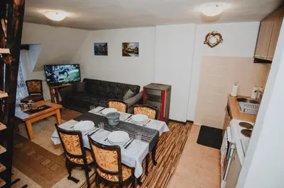 a living room with a table with chairs and a couch at Apartments Kiki Vlašić in Vlasic