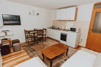 a living room with a table and a kitchen at Apartments Kiki Vlašić in Vlasic