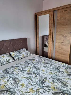 a bedroom with a bed with a floral bedspread at Apartman Mia 2 Banja Luka in Banja Luka