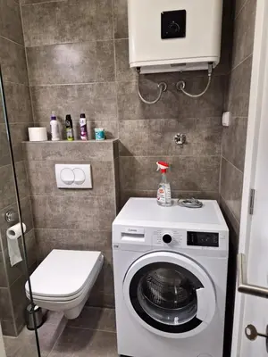 a bathroom with a washing machine and a toilet at Apartman Mia 2 Banja Luka in Banja Luka