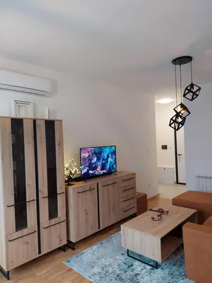 a living room with a couch and a tv on a cabinet at Apartman Mia Banjaluka in Banja Luka