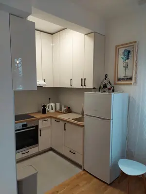 a kitchen with white cabinets and a refrigerator at Apartman Mia Banjaluka in Banja Luka