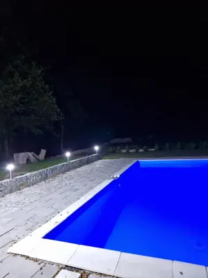 a blue pool in the middle of a yard at night at Eurouna relax in Bosanska Krupa