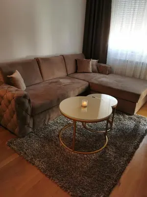 a living room with a brown couch and a coffee table at Alex LUX in Banja Luka
