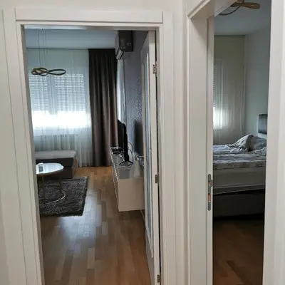 a room with a bedroom with a bed and a television at Alex LUX in Banja Luka