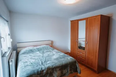 a bedroom with a bed and a wooden cabinet at CosyHouse-Kupres in Kupres