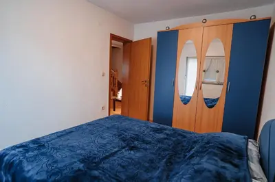 a bedroom with a blue bed and a wooden door at CosyHouse-Kupres in Kupres