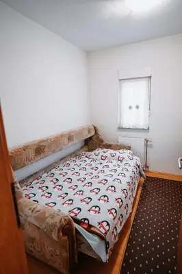 a bed in a small room with a blanket on it at CosyHouse-Kupres in Kupres