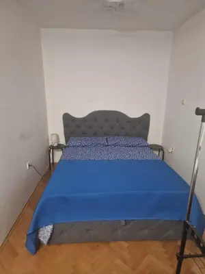 a bed in a room with a blue blanket on it at Villa Janković in Modriča