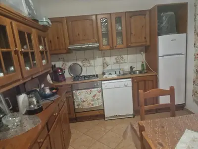 a kitchen with wooden cabinets and a white refrigerator at Villa Janković in Modriča