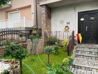 a garden with a hose in front of a house at Villa Janković in Modriča