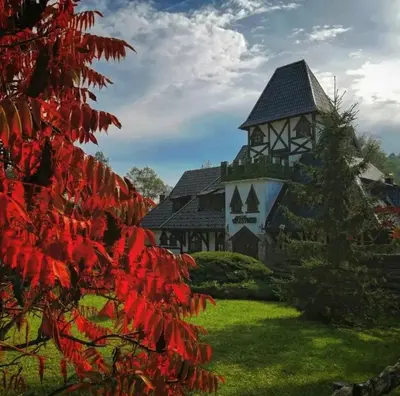 a house with a red tree in front of it at Kraljevsko selo Kotromanićevo in Doboj
