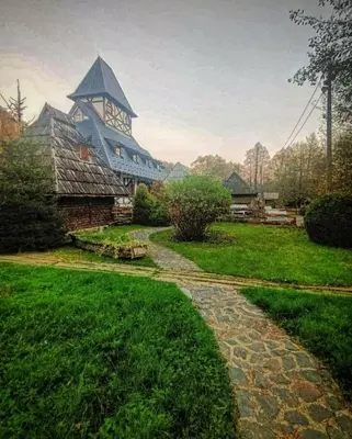 a stone path leading to a building with a clock tower at Kraljevsko selo Kotromanićevo in Doboj