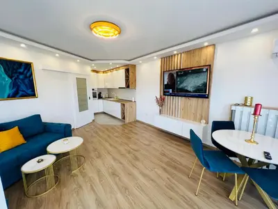 a living room with a blue couch and a table and chairs at GRAND LUX Mihajlo in Doboj