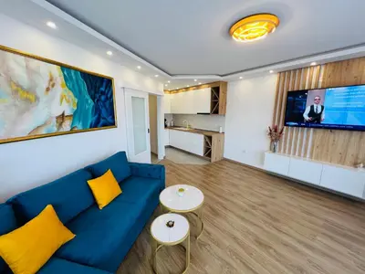 a living room with a blue couch and a tv at GRAND LUX Mihajlo in Doboj